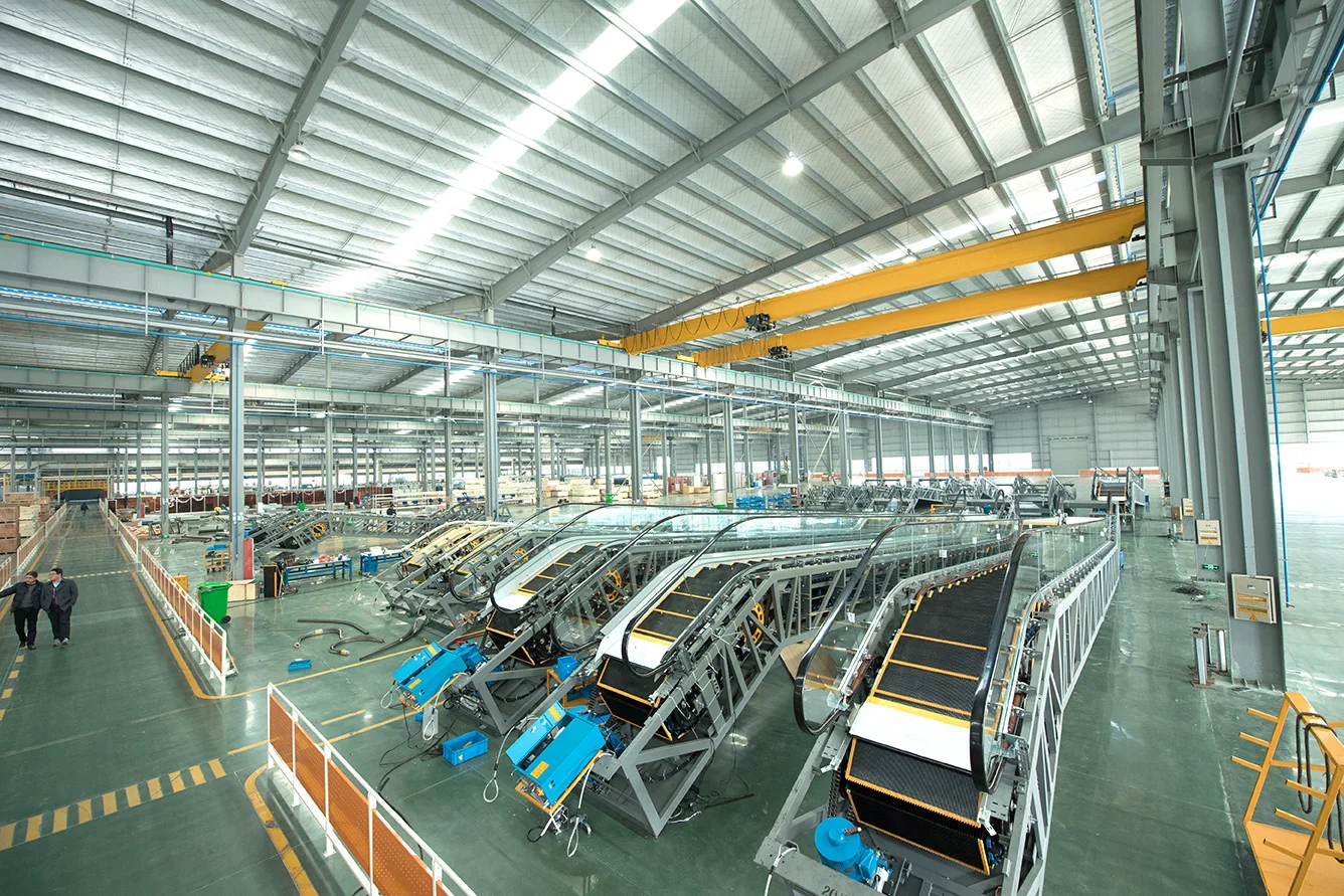 Wide view of an industrial assembly hall with several escalators in production fixtures